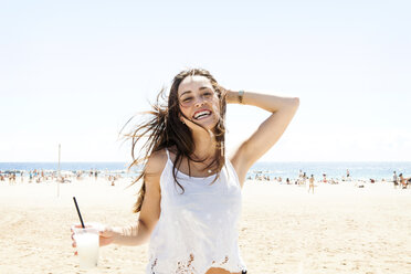 Young woman drinking cocktail on the beach - VABF000642