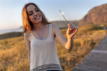 Young woman at the beach playing with sparklers - MGOF002003