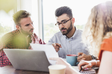 Drei junge Berufstätige bei einem Treffen im Büro - UUF007850