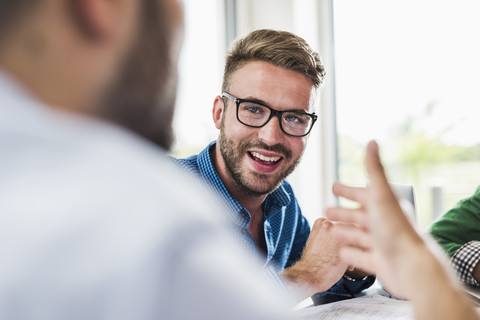 Selbstbewusster junger Berufstätiger in einer Besprechung, lizenzfreies Stockfoto