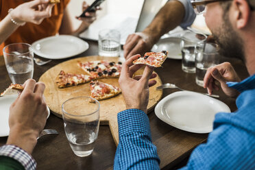 Colleagues at table having a pizza - UUF007899