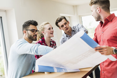 Junge Berufstätige diskutieren im Büro über ihren Plan - UUF007908