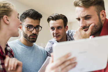 Junge Berufstätige schauen sich das digitale Tablet an - UUF007910