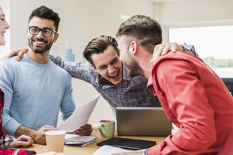 Lachende junge Berufstätige im Büro, lizenzfreies Stockfoto