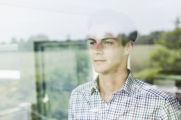 Young man looking out of window - UUF007923