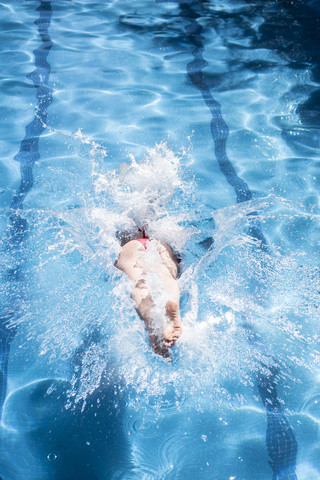 Frau springt in einen Pool, lizenzfreies Stockfoto