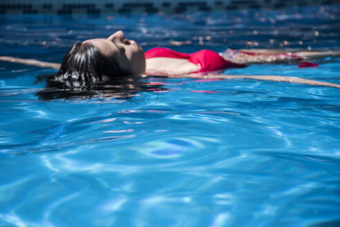 Frau schwimmt auf dem Wasser eines Schwimmbeckens - ABZF000746