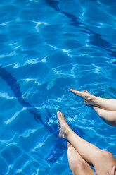 Beine von zwei Frauen im Wasser eines Pools - ABZF000761