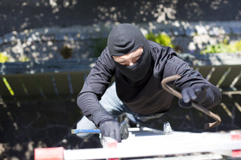 Einbrecher mit Brecheisen klettert Leiter an Hauswand hoch - MAEF011852