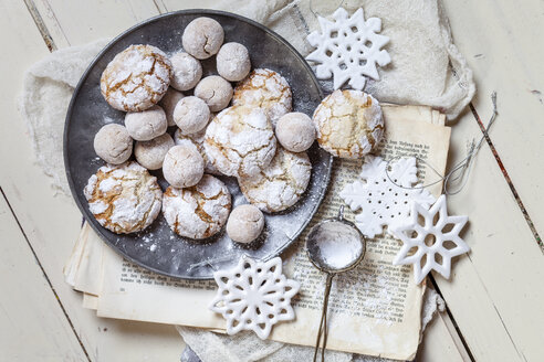 Selbstgebackene Weihnachtsplätzchen mit Puderzucker auf altem Buch - SBDF002969