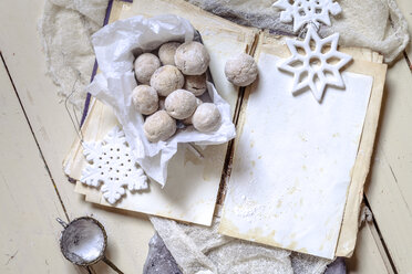 Selbstgebackene Weihnachtsplätzchen mit Puderzucker auf altem Buch - SBDF002971