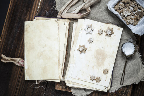 Selbstgebackene Weihnachtsplätzchen mit Puderzucker auf altem Buch - SBDF002973