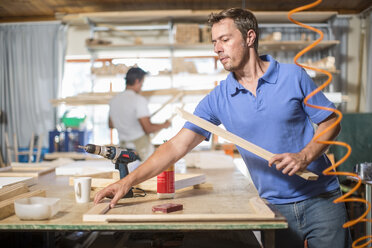 Zwei Männer arbeiten in einer Leinwandwerkstatt - ZEF008824