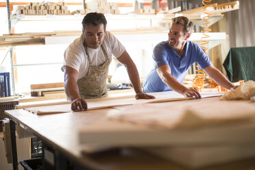 Two men working together in canvas workshop - ZEF008827