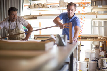 Two men working together in canvas workshop - ZEF008828