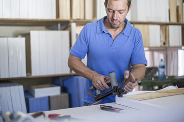 Man working on frame in canvas workshop - ZEF008832