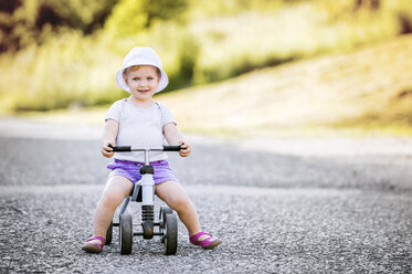 Portrait of smiling toddler girl on toy car - HAPF000545