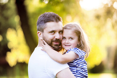 Portrait of happy father holding smiling little daughter on his arms - HAPF000568