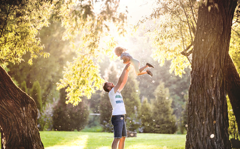 Vater und seine kleine Tochter haben Spaß im Park, lizenzfreies Stockfoto