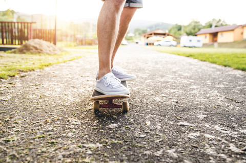 Beine eines Mannes, der auf einem Skateboard steht, lizenzfreies Stockfoto