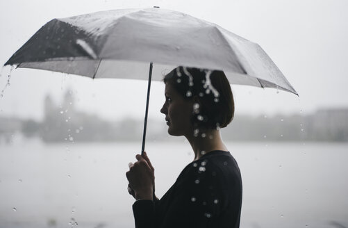 Frau mit Regenschirm an einem regnerischen Tag - DASF000053