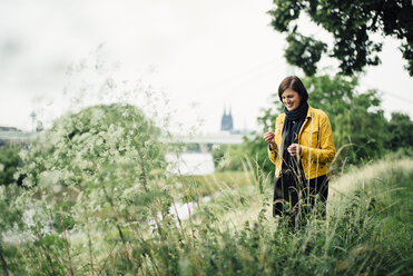 Germany, Cologne, happy woman standing on a meadow - DASF000054