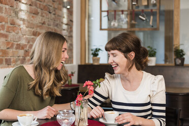 Two best friends sitting in a coffee shop having fun - KAF000170