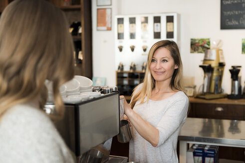 Barista bei der Arbeit im Gespräch mit dem Kunden - KAF000175