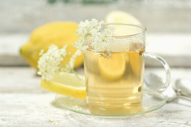 Holunderblütentee, Teetasse und Holunderblüten, Zitrone im Hintergrund - ASF005924