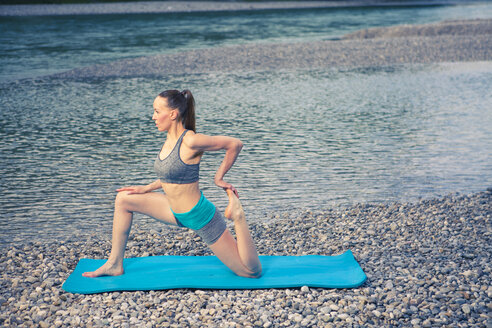 Frau übt Yoga am Flussufer - YNF000002