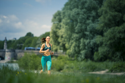 Junge Frau joggt in der Natur - YNF000011