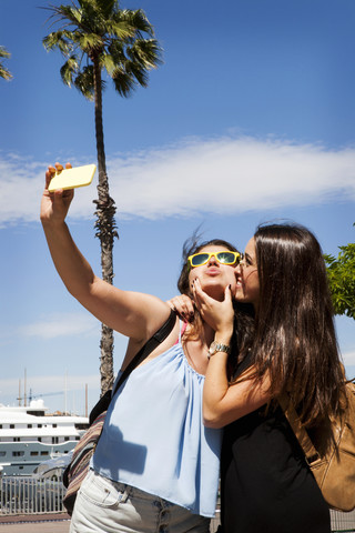 Spanien, Barcelomna, zwei beste Freunde machen ein Selfie mit Smartphone, lizenzfreies Stockfoto