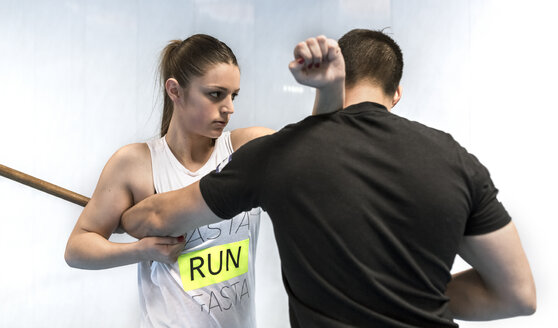 Junge Frau im Fitnessstudio beim Selbstverteidigungstraining - MGOF002023