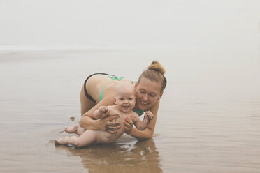 Mutter und kleiner Junge spielen im Wasser am Strand - KNTF000410