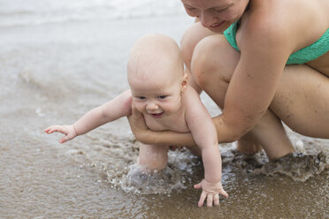 Mutter und kleiner Junge spielen im Wasser am Strand - KNTF000412