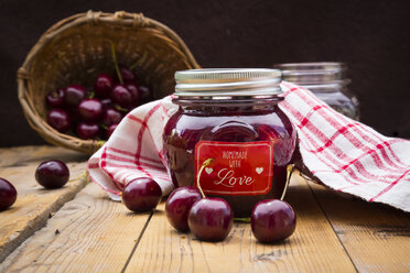 Glass of homemade cherry groats, dish towel and cherries on wood - LVF005069