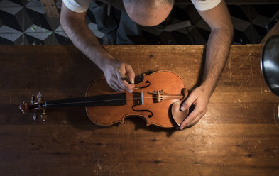 Luthier adjusting the sound post of a violin in his workshop - ABZF000789