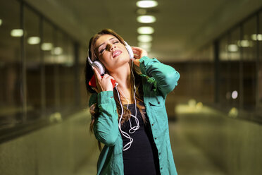 Junge Frau mit Kopfhörern und Smartphone - SIPF000585