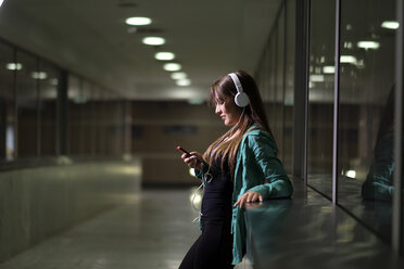 Junge Frau mit Kopfhörern und Smartphone - SIPF000586