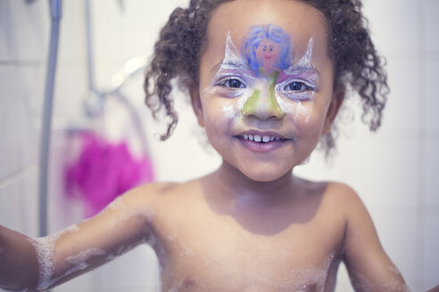 Porträt eines lächelnden kleinen Mädchens mit bemaltem Gesicht in einer Badewanne - YNF000014