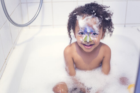 Porträt eines lächelnden kleinen Mädchens mit bemaltem Gesicht, das in einer Badewanne sitzt - YNF000015