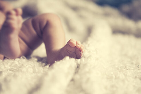 Afro-europäisches Baby, Füße auf einer kuscheligen weißen Decke - YNF000019