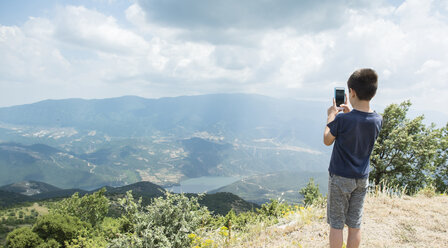 Greece, Central Macedonia, boy taking smartphone picture in the mountains - DEGF000861