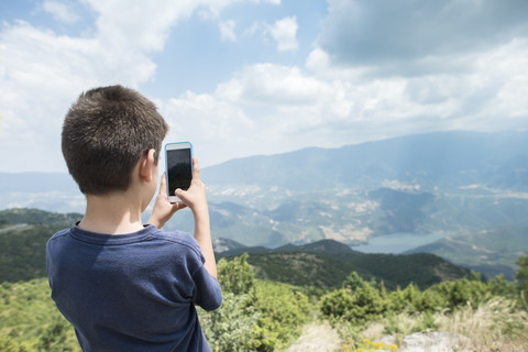 Griechenland, Zentralmazedonien, Junge macht Smartphone-Foto in den Bergen, lizenzfreies Stockfoto