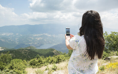 Greece, Central Macedonia, woman taking smartphone picture in the mountains - DEGF000871