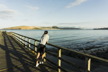 New Zealand, Whangamata, back view of man on a jetty - UUF007930