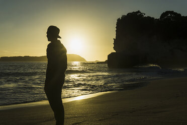 Neuseeland, Wanganui, Silhouette eines Mannes, der am Strand steht und auf das Meer schaut - UUF007942