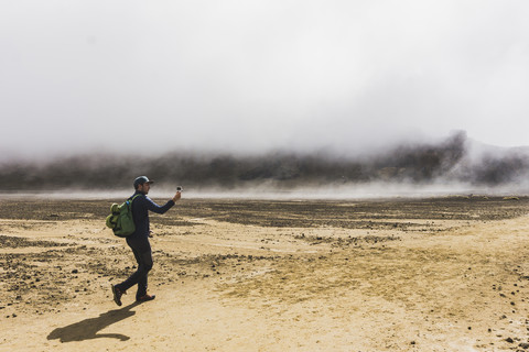 Neuseeland, Tongariro National Park, Wanderer beim Fotografieren mit Smartphone, lizenzfreies Stockfoto