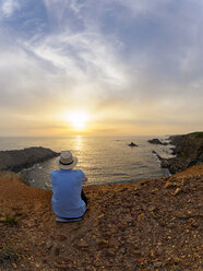 Portugal, Senior man sitting at bay watching sunset - LAF001679