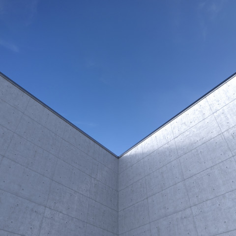 Hohe Betonwand vor blauem Himmel, 3D Rendering, lizenzfreies Stockfoto